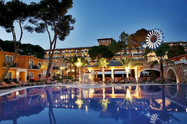 Abendlicher Blick auf das Hotel Occidental Playa de Palma mit Swimmingpool und Lounge-Bereich.