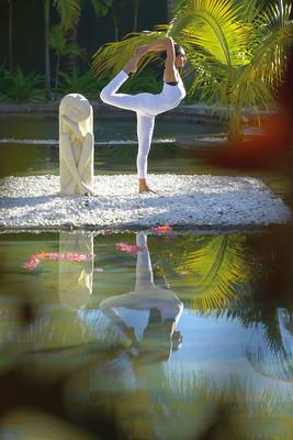 Eine Frau praktiziert Yoga am Pool im Paradis Beachcomber Golf Resort & Spa.