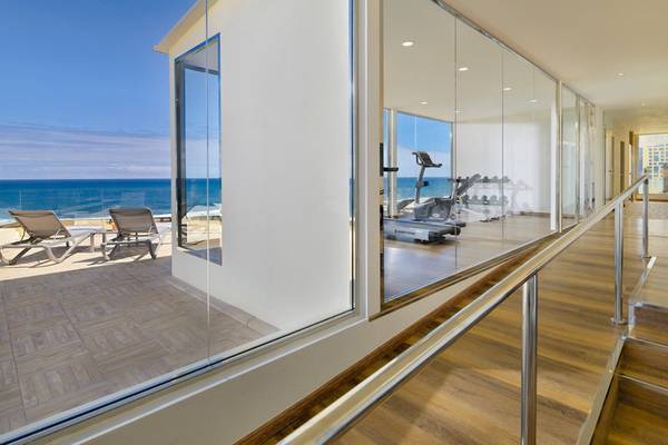 Innenansicht des H10 Tenerife Playa Hotels mit Terrasse und Fitnessraum.