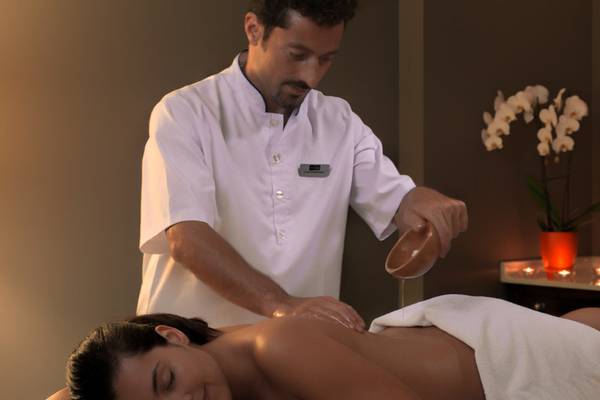 Massage im H10 Tenerife Playa Hotel, Mann massiert Frau auf Liege
