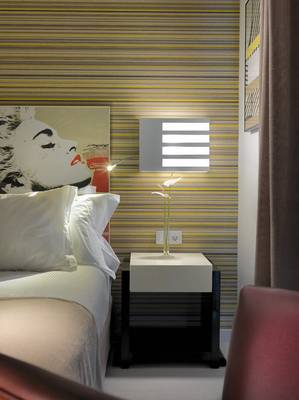 Zimmer im H10 Tenerife Playa Hotel mit Bett und Wandbeleuchtung