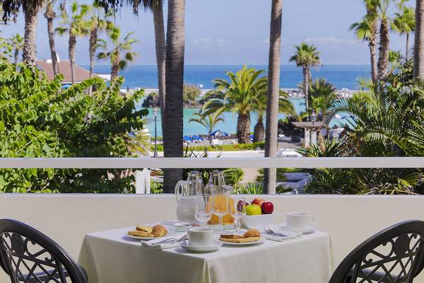 Frühstückstisch auf dem Balkon des H10 Tenerife Playa mit Meerblick, Früchten und Getränken.
