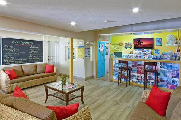 Lobbybereich des Coconut Court Beach Hotels mit Sofas, Couchtischen und einer Theke.
