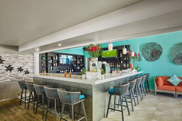 Bar im Coconut Court Beach Hotel mit Holzboden und modernen Stühlen