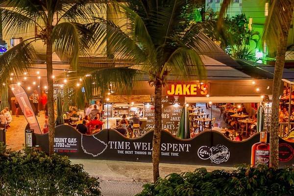 Außenbereich des Coconut Court Beach Hotels bei Nacht mit beleuchteten Palmen und Gästen.