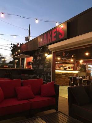 Abendstimmung in Jake's Bar mit roten Sofas und Beleuchtung.