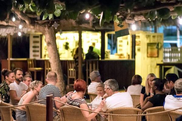 Menschen essen im Freien unter Bäumen im Coconut Court Beach Hotel
