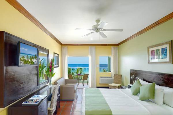 Schlafzimmer im Coconut Court Beach Hotel mit Meerblick und komfortabler Einrichtung.