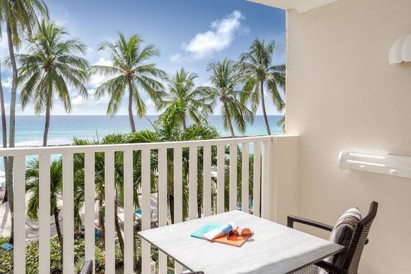 Blick vom Balkon des Sugar Bay Barbados Hotels auf den Ozean mit Palmen und Sandstrand