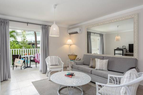 Wohnzimmer von Sugar Bay Barbados mit Sofa, Tisch, Stühlen und Spiegel