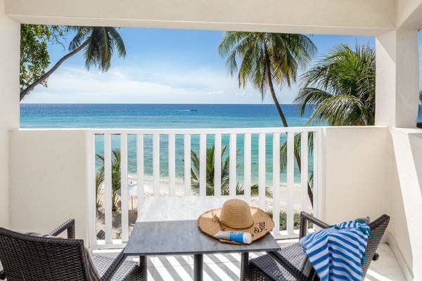 Balkon im Sugar Bay Barbados Hotel mit Blick auf den Ozean und weißem Sandstrand.