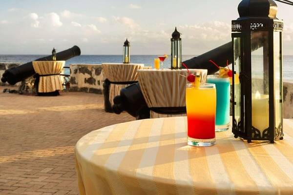 Cocktails auf der Terrasse des Hilton Barbados mit Blick auf das Meer und Kanonen im Hintergrund.