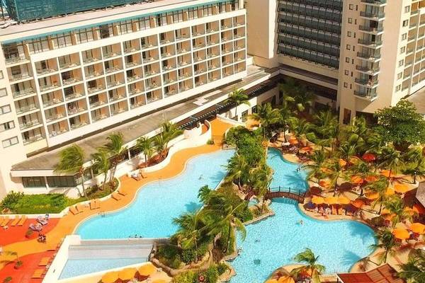 Luftaufnahme des Hilton Barbados Hotels mit Swimmingpool und Palmen.