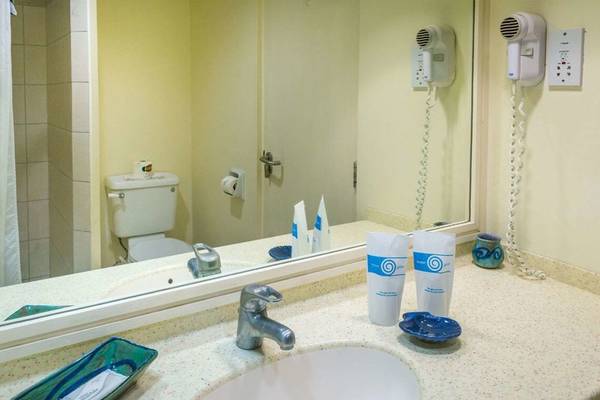 Badezimmer im Rostrevor Hotel mit Spiegel, Waschbecken und Toilette.