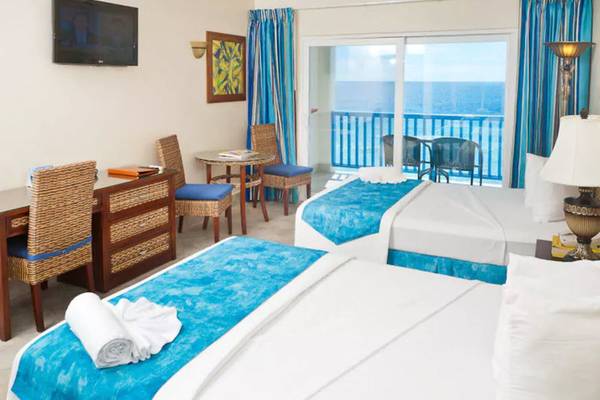 Doppelzimmer im Rostrevor Hotel mit Meerblick, zwei Betten, Schreibtisch und Balkon.