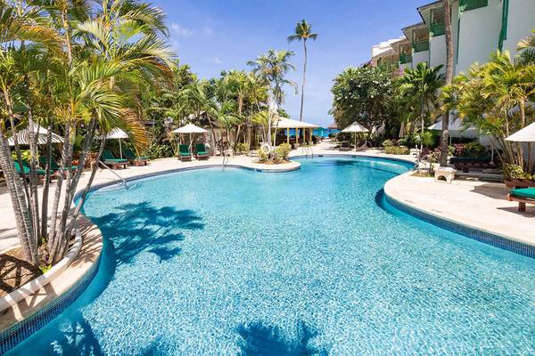 Außenpool des Mango Bay Hotels umgeben von Palmen und Lounge-Stühlen