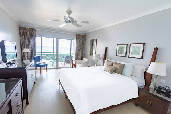 Schlafzimmer im Mango Bay Hotel mit großem Bett, Fernseher, Schreibtisch und Balkonzugang