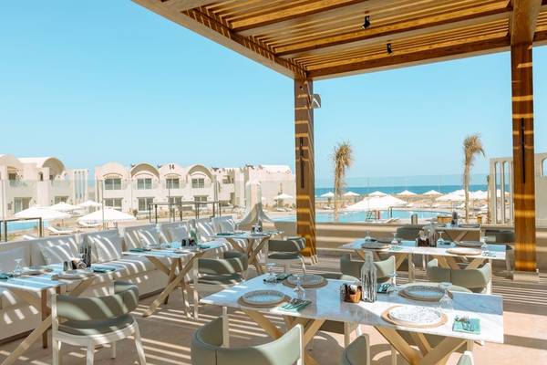 Terrasse im Sunrise Anjum Resort mit Blick auf den Pool und das Meer.