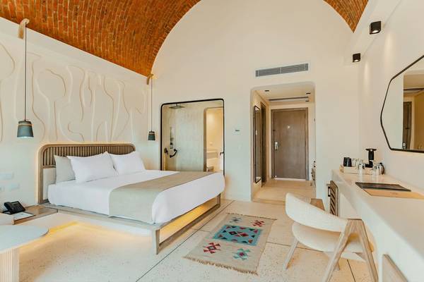 Zimmer im Sunrise Anjum Resort mit Bett, Schreibtisch und moderner Einrichtung.