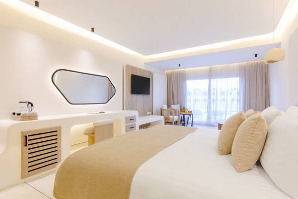 Ein modernes Hotelzimmer im Sunrise Anjum Resort mit einem großen Bett, weißen Wänden und einem Fernseher.