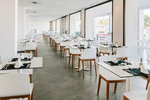 Innenansicht des AluaSoul Ibiza Restaurants mit vielen weißen Tischen und Stühlen.