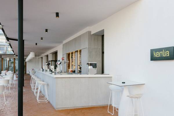 Barbereich im AluaSoul Ibiza Hotel mit weißen Stühlen und einer Theke.