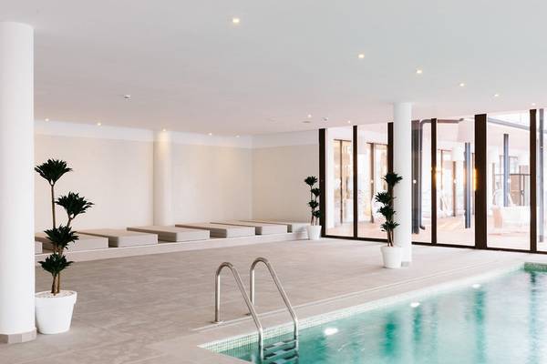 Innenpool des AluaSoul Ibiza Hotels mit Sonnenliegen und Pflanzen