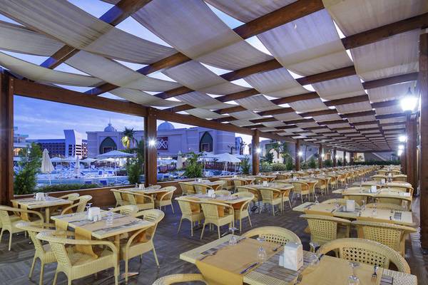 Terrasse Restaurant im Alan Xafira Deluxe Resort & Spa Hotel mit vielen Tischen und Stühlen.