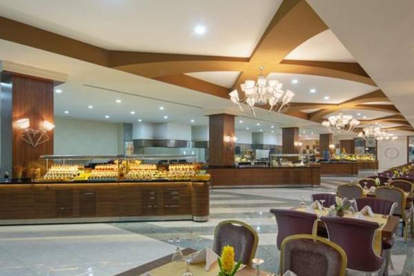 Innenansicht des Restaurants im Alan Xafira Deluxe Resort & Spa mit vielen Tischen und Stühlen.