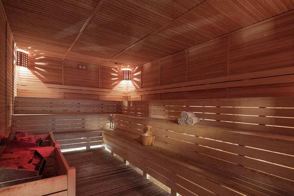 Sauna im Alan Xafira Deluxe Resort & Spa mit Holzwänden, Bänken und einer Holzschale mit einem Besen.