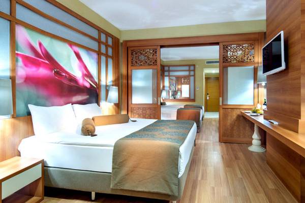 Hotelzimmer im Alan Xafira Deluxe Resort & Spa mit großem Bett und modernen Möbeln.