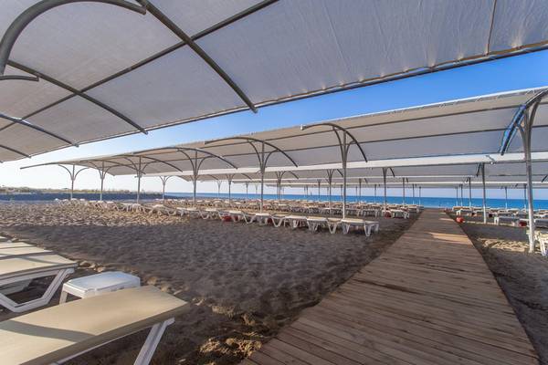 Strandbereich des Sensitive Premium Resort & Spa mit Sonnenliegen unter Sonnenschutzzelten