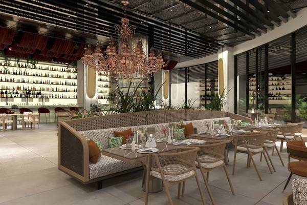 Innenansicht des Ethno Belek Restaurants mit Tisch, Stühlen, einem großen Kronleuchter und Regalen mit Flaschen.
