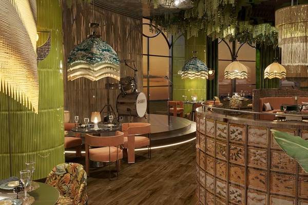 Innenansicht des Ethno Belek Restaurants mit grünen Wänden, Holzboden, und dekorativen Lampen.