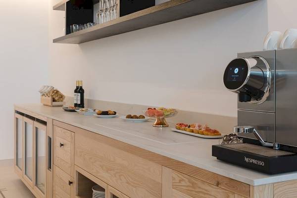 Buffet im Plus Fariones Suite Hotel mit Espressomaschine, Snacks und Getränken.