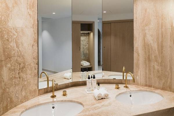 Luxuriöses Badezimmer im Plus Fariones Suite Hotel mit Marmorboden, zwei Waschbecken und einem Spiegel.