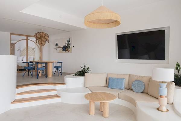 Wohnbereich im Plus Fariones Suite Hotel mit weissen Möbeln, blauen Kissen und einer modernen Einrichtung.