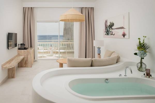 Innenansicht des Plus Fariones Suite Hotels mit Wohnbereich und Badewanne am Balkon