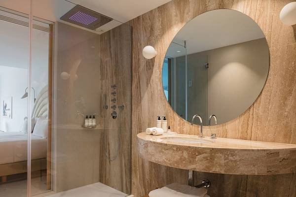 Badezimmer im Plus Fariones Suite Hotel mit Regendusche, Waschbecken und großem Spiegel.