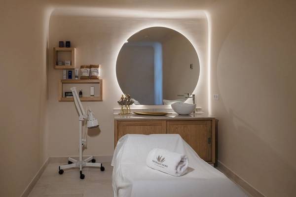 Behandlungstisch im Beauty-Salon des Plus Fariones Suite Hotels, mit einem großen Spiegel und einem weißen Handtuch.