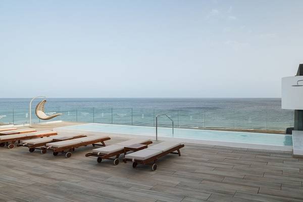 Außenpool mit Liegen am Plus Fariones Suite Hotel mit Blick auf das Meer
