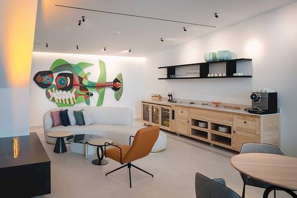 Inneneinrichtung des Plus Fariones Suite Hotel mit modernem Design, Couch, Tisch, Stühle und Wandkunstwerk.