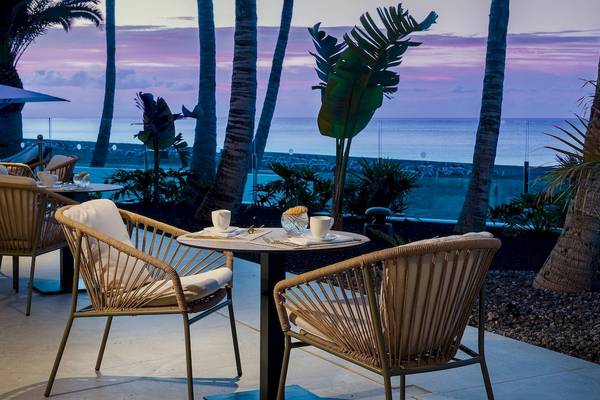 Terrasse des Plus Fariones Suite Hotels mit Blick auf den Ozean und den Sonnenuntergang.