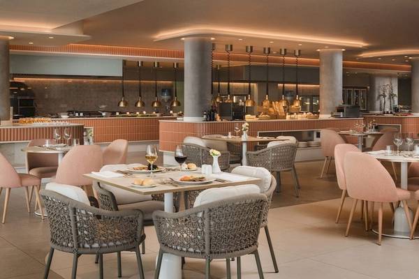 Innenansicht des Restaurants im Plus Fariones Suite Hotel mit gepolsterten Stühlen und Tischen.