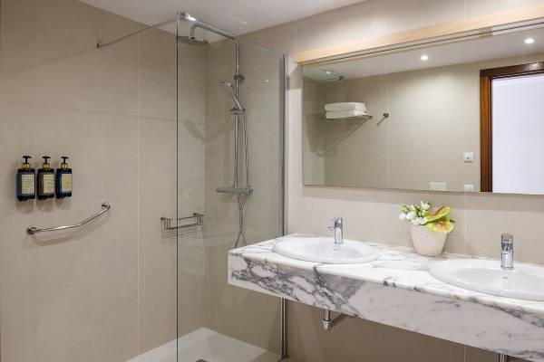 Badezimmer im Plus Fariones Suite Hotel mit doppelwaschbecken, spiegel und dusche