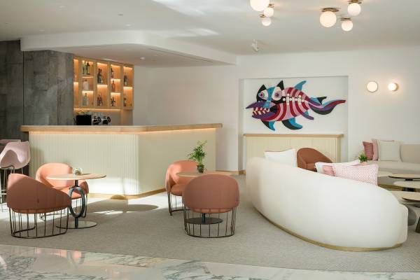 Lobby des Plus Fariones Suite Hotels mit Bar, buntem Fischbild und modernen Möbeln.