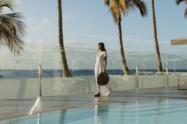 Frau in weissem Kleid am Pool von Plus Fariones Suite Hotel