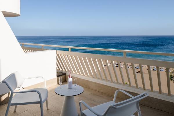Terrasse des Plus Fariones Suite Hotels mit Blick auf den Ozean und einen Strand