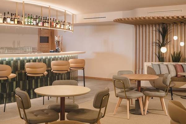 Innenbereich des Plus Fariones Suite Hotels mit Bar, Tischen und Stühlen.