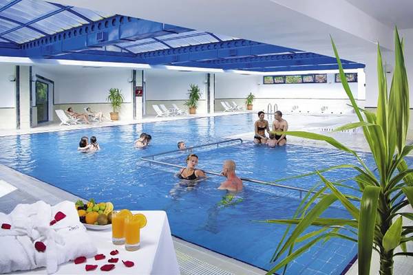 Besucher im Innenpool des Richmond Ephesus Resorts, einige schwimmen, andere entspannen.
